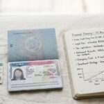 Green card and H1B visa documents with financial planning notebook representing long-term immigration cost planning